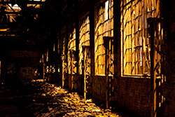 abandoned building with broken windows and yellow light