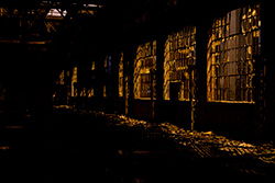 broken windows and glass in abandoned building with light from street