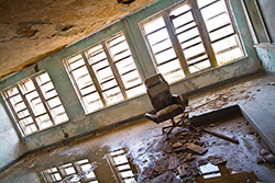 abandoned school classroom with chair, stage and blackboard