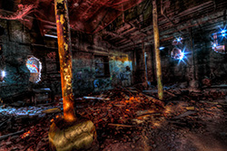 sous-sol usine abandonnée avec débris et piliers de soutien