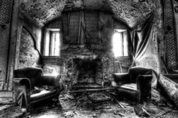 haunted house with fireplace and armchairs, light from windows, black and white photo