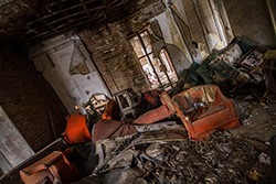 old armchairs and dirty objects in abandoned house interior