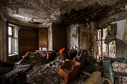intérieur de maison abandonnée avec vieux fauiteuil et débris sur le sol