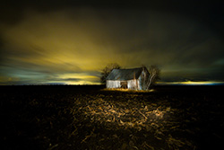 light painting sur vielle grange dans un champ de boue