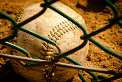 baseball behind fence on the ground