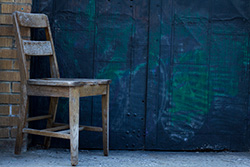 chaise devant porte avec graffiti