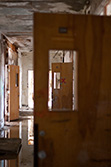 opened doors in abandoned corridor with water on floor