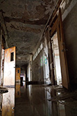 school corridor with open doors and water on floor