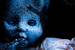 creepy doll portrait with spray paint splatters