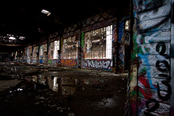 abandoned factory interior with spray paintings and broken windows