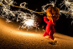 winter party doll on snow, lighted by burning sparkler, lightpainting