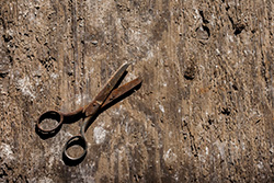 old rusty scissors on wooden floor with dust