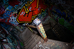 dirty spiral staircase in dilapidated factory with graffiti