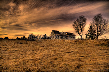 Vieille maison abandonnée dans un champ avec arbres et ciel nuageux, photo HDR