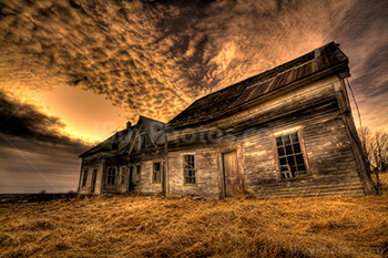 Vieille mainson abandonnée dans un champ avec ciel nuageux, sur photo couleur HDR