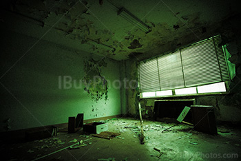 Bureau abandonné avec stores vénitiens et meuble cassé, lueur verte
