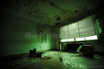 Abandoned office with broken furniture in dilapidated building, green light