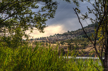 Lac du Salagou avec roseaux et colline en image HDR