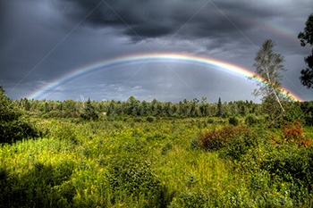 Arc-en-ciel complet en photo HDR pendant orage avec nuages gris