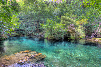 Rivière de la Vis aux eaux turquoise, entourée d'arbres et buissons sur photo HDR