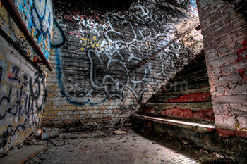Cage d'escaliers avec marches et lumière sur le mur avec graffiti, HDR