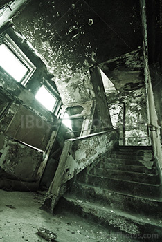 Stairs art lighting in abandoned asylum, with light through windows