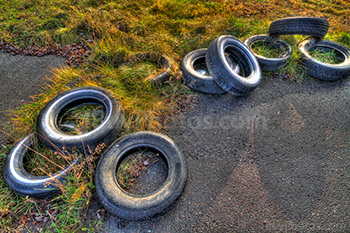 Pneus usés sur route, posés sur le sol, asphalte et herbe