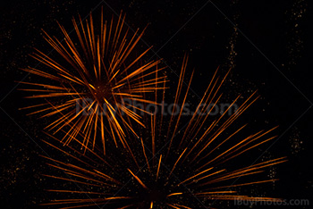 Orange fireworks explosions with sparkles