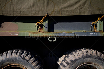 Military truck with camouflage tarp attached with rope