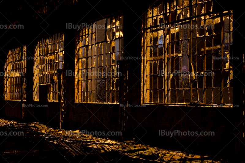 Broken windows frames with glass and fragments on floor