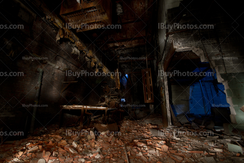 Sous-sol abandonné avec débris et murs démolis, éclairée par lightpainting