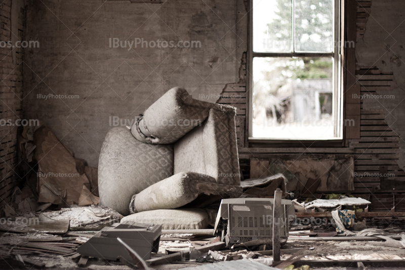 Chambre de maison abandonnée avec fauteuil renversé et mobilier cassé
