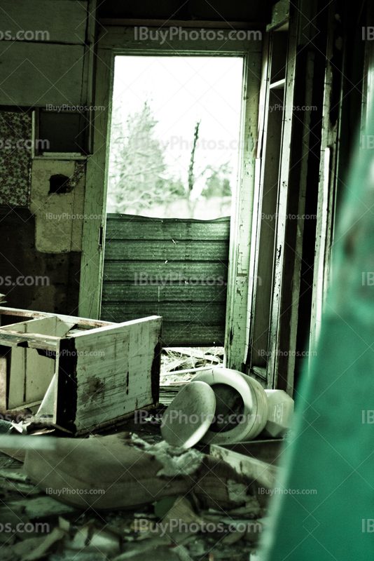 Abandoned house room with toilet and furniture, light coming from door