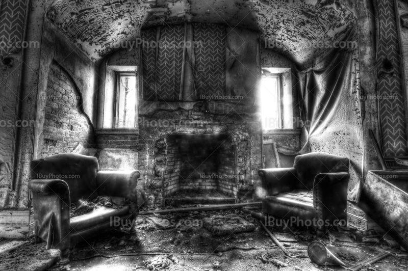 Haunted house with fireplace and armchairs, light from windows, black and white photo