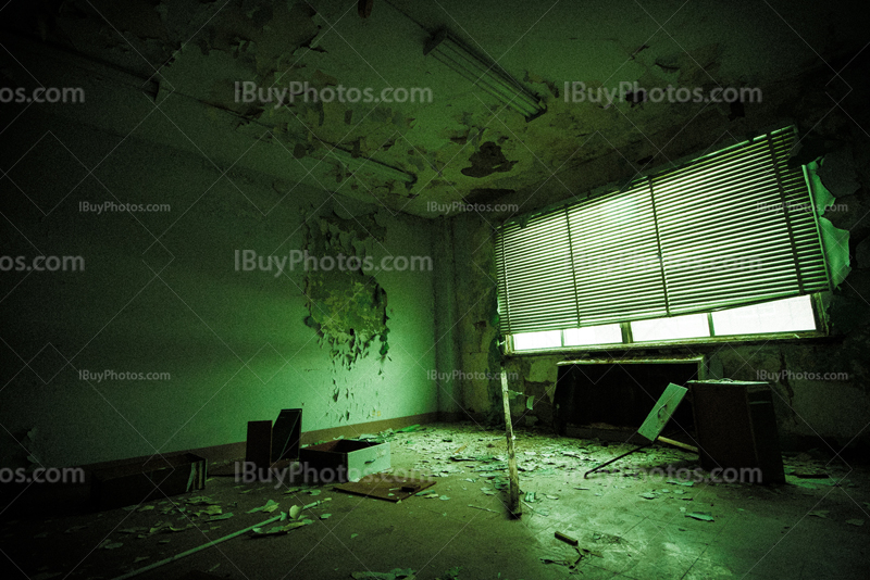 Abandoned office with broken furniture in dilapidated building, green light