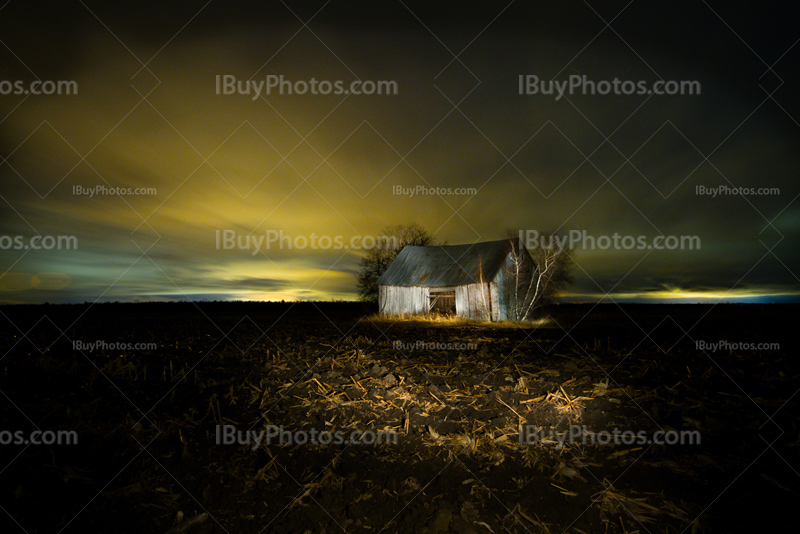 Light painting sur vielle grange dans un champ de boue