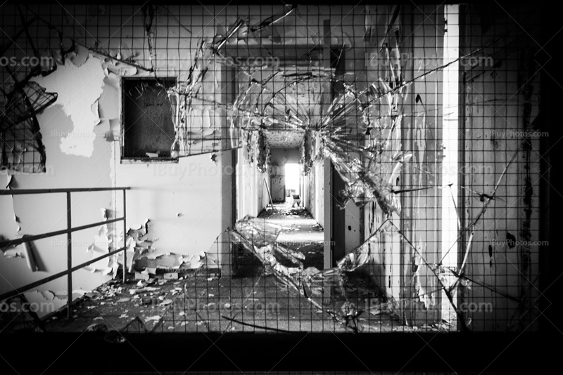 Impact on broken window in derelict building, black and white photo