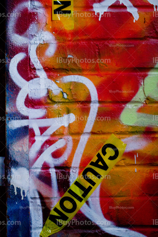 Caution tape and graffitis on wall in abandoned place