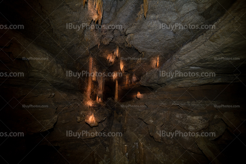 Intérieur de grotte en perspective avec lumière sur stalactites et stalagmites