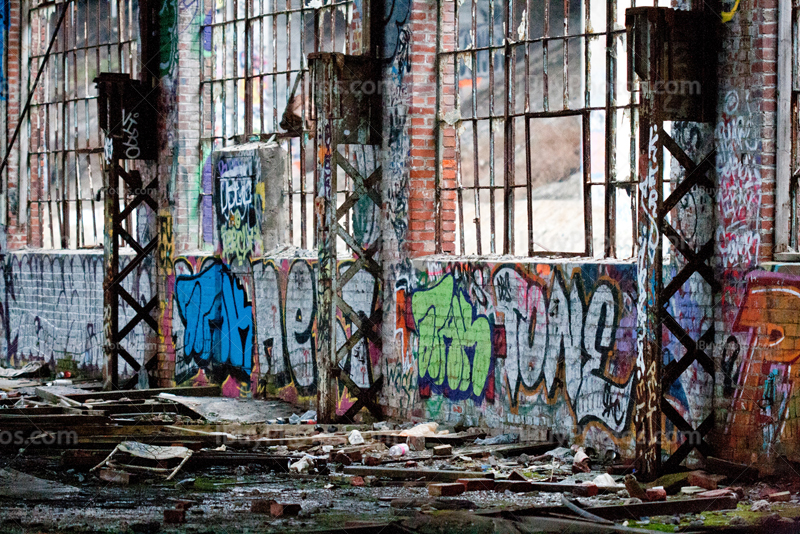 Crumbling wall and broken windows in derelict building interior