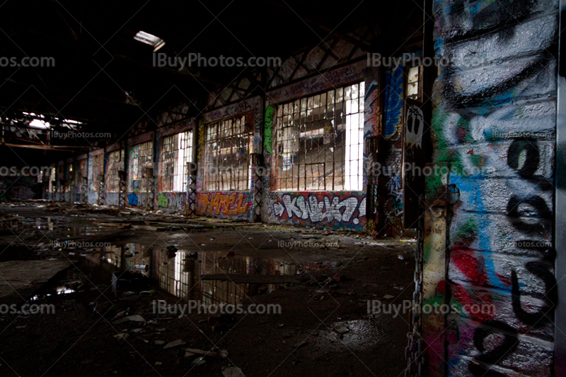 Abandoned factory interior with spray paintings and broken windows