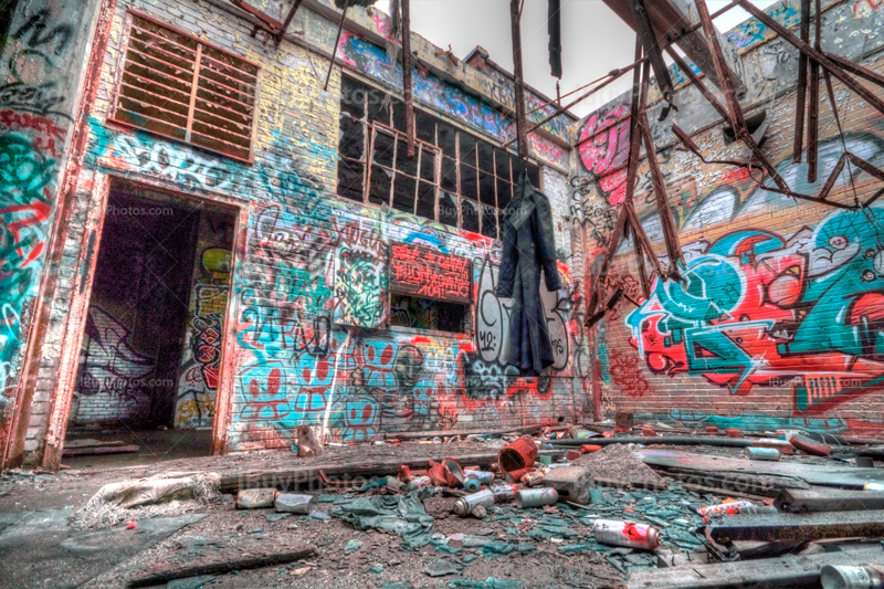 Dirty coat in derelict building with graffiti on walls and spray cans, HDR