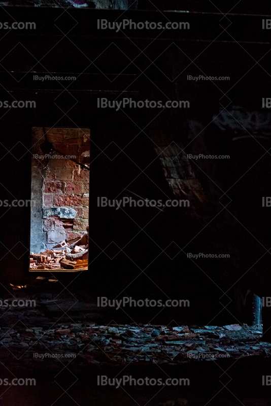 Doorway in dark room with damaged wall