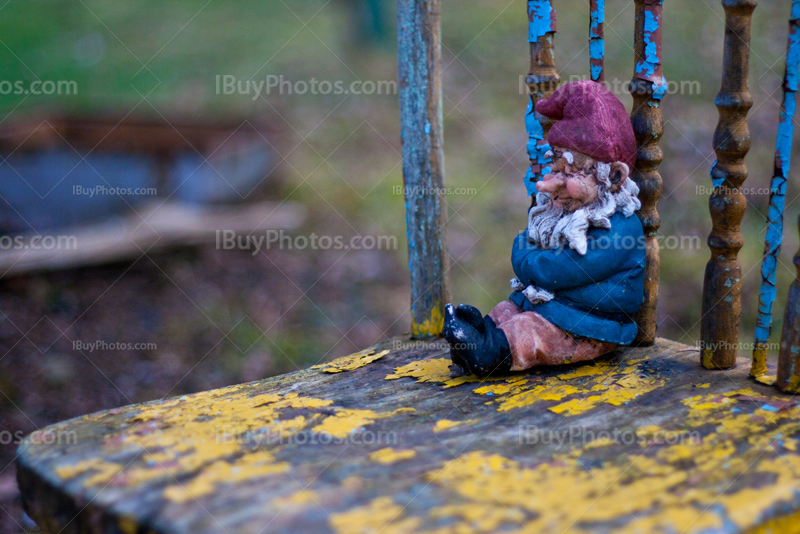 Garden gnome seating on old chair close-up