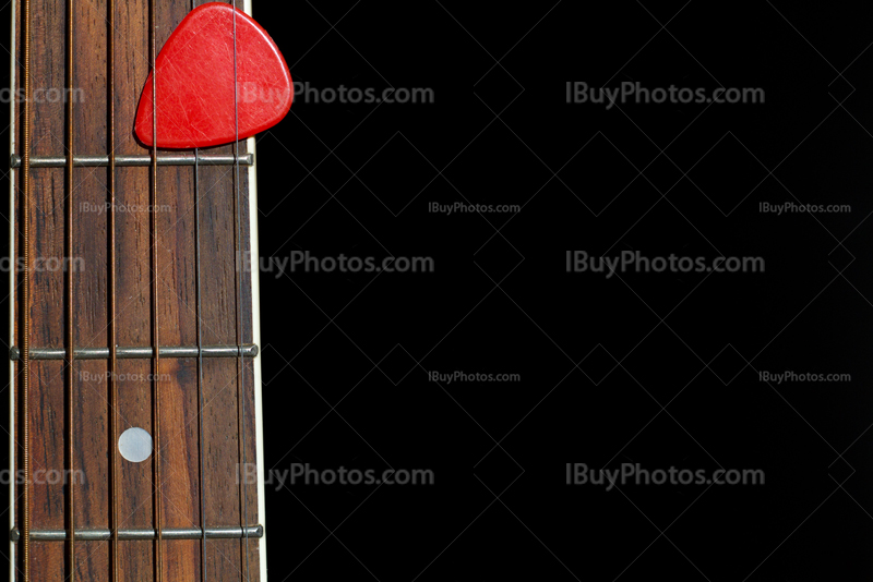 Plectrum on guitar with strings and fingerboard