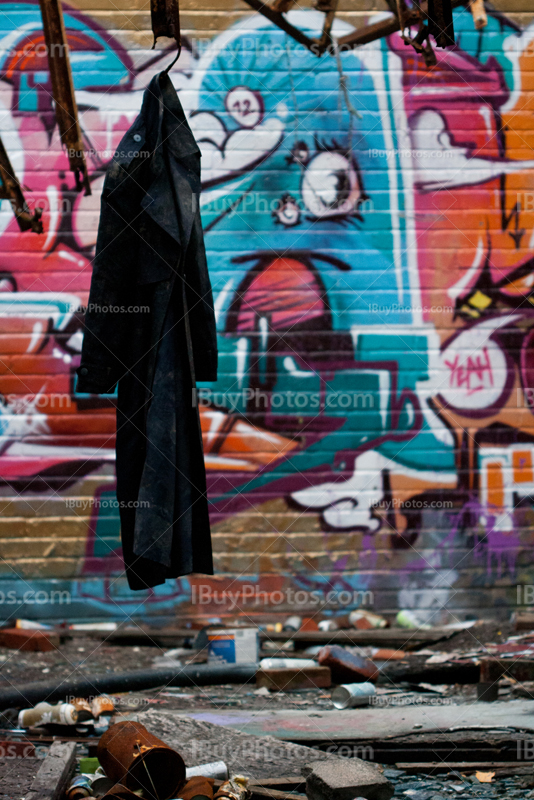 Coat hung in dirty room in abandoned place with spray paintings