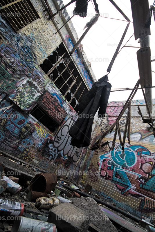 Low-angle picture of coat hanging in dirty place with graffiti