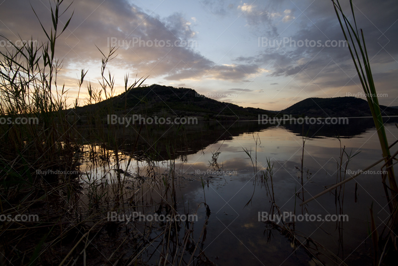 Coucher de soleil au lac du Salagou avec roseaux et nuages