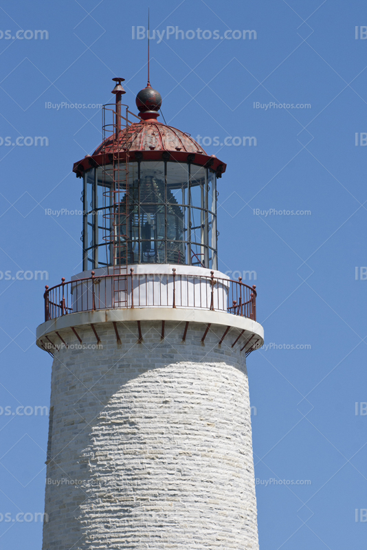 Lighthouse tower and lantern on blue sky