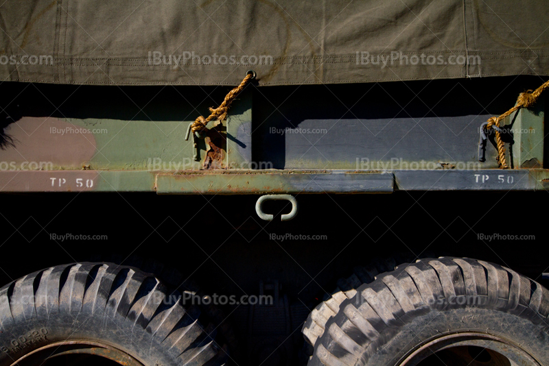 Military truck with camouflage tarp attached with rope